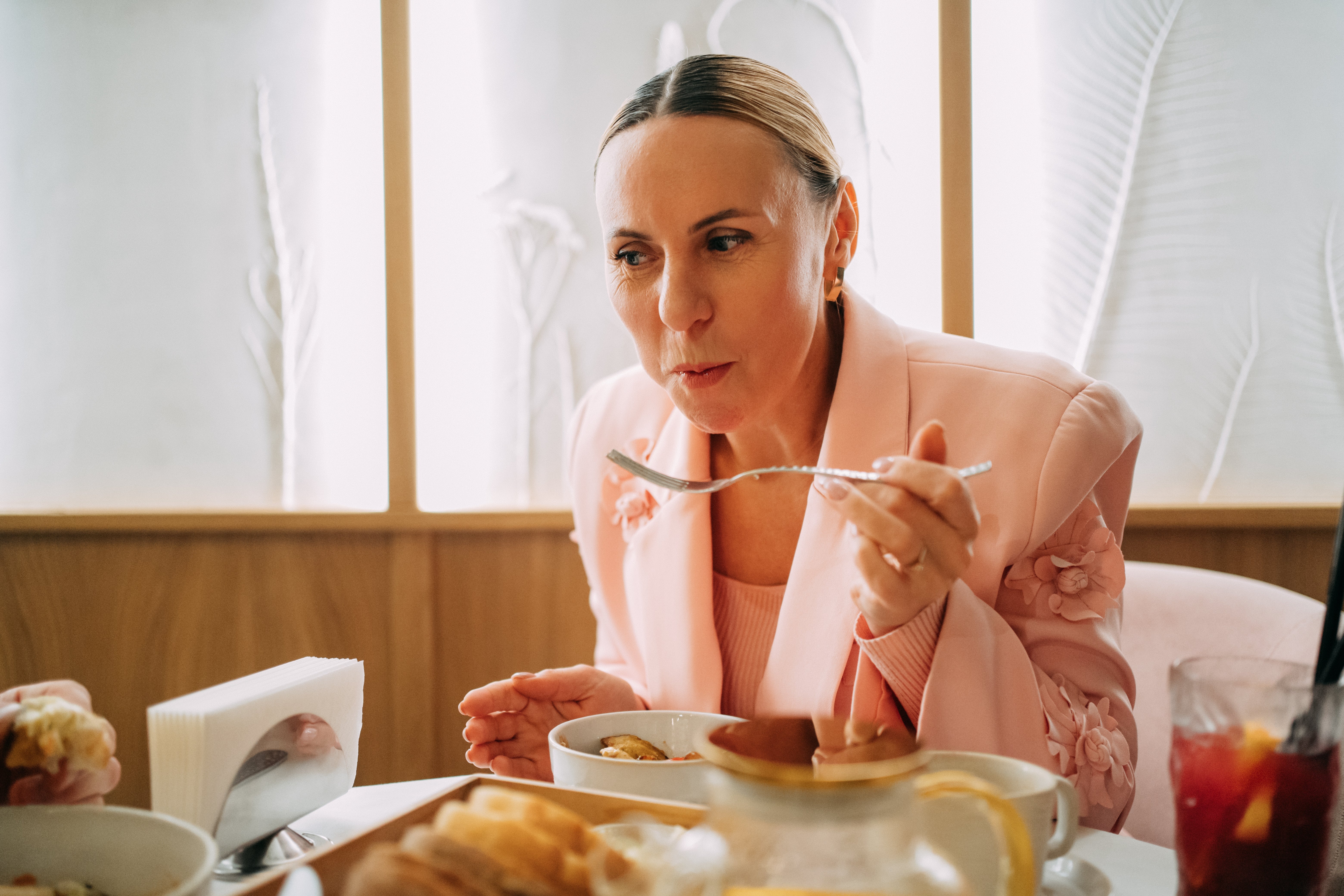 Person successful elegant outfit enjoys a repast astatine a eating table, suggesting a absorption connected nutrition oregon mindful eating