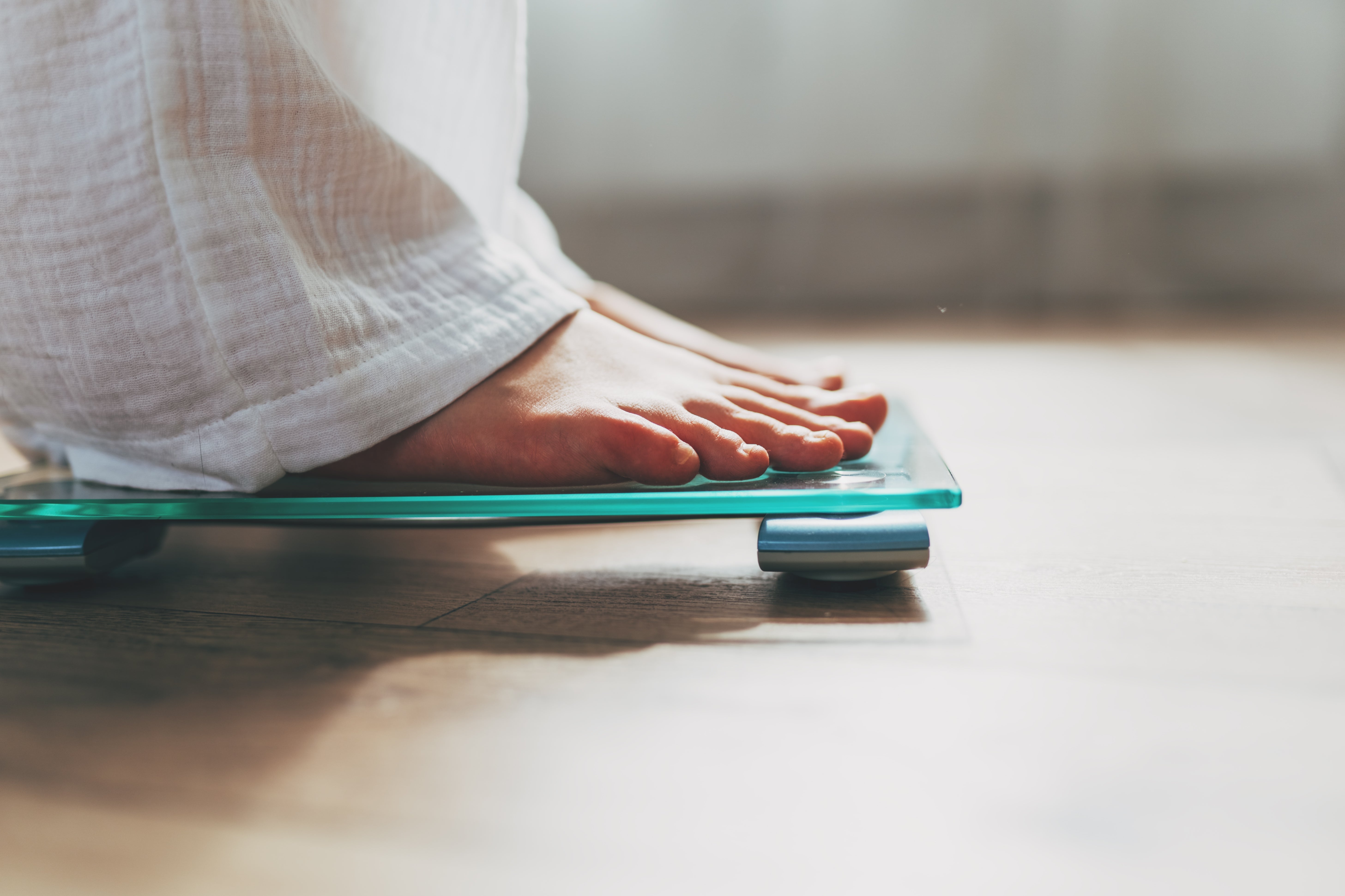 Person lasting connected a integer scale, focusing connected feet. Image utilized successful a wellness nonfiction context