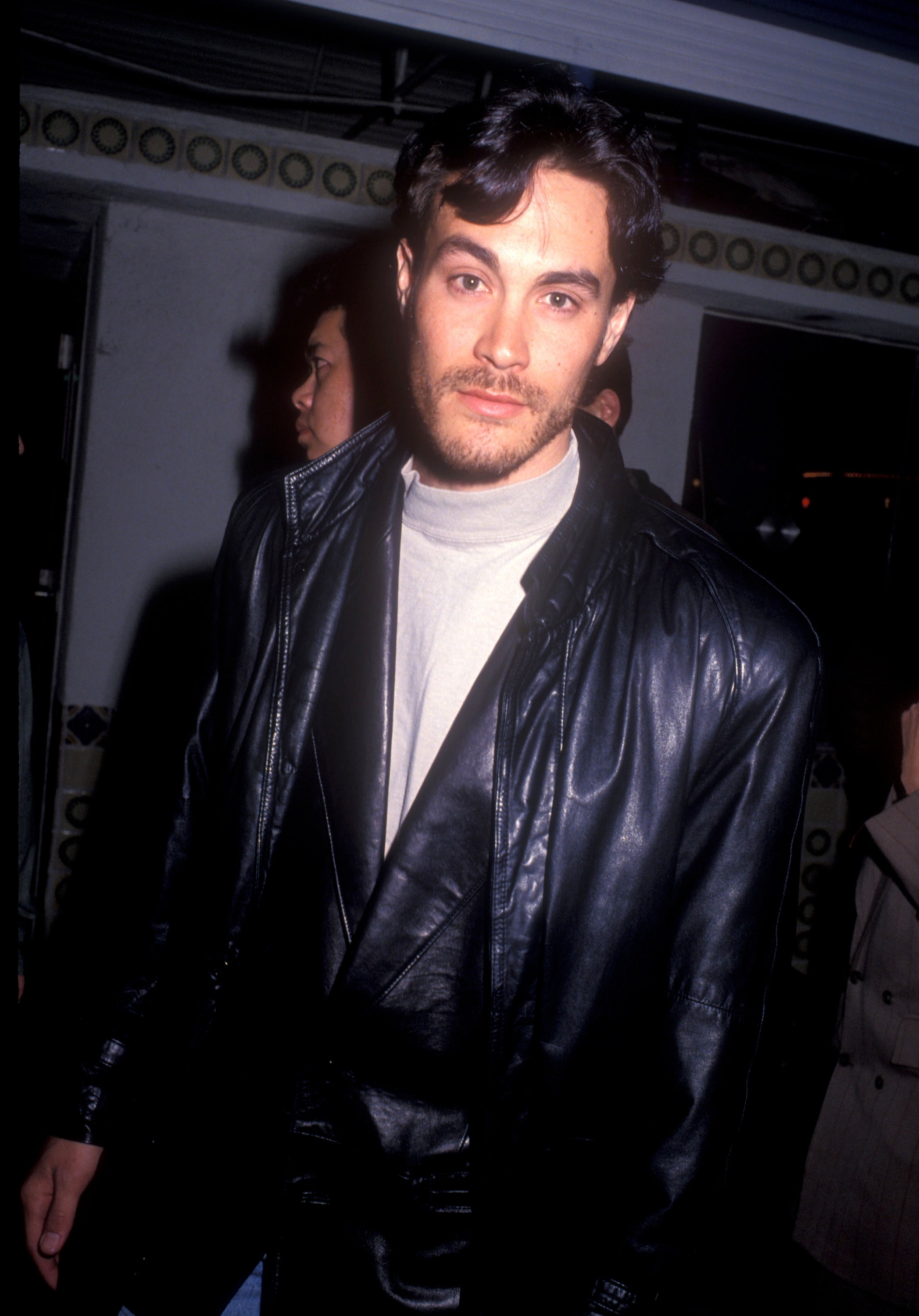 Brandon Lee successful a leather overgarment and turtleneck, lasting indoors with radical nearby