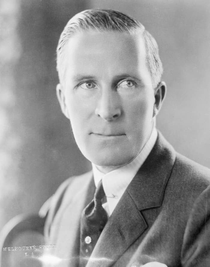 A portrait of a man in formal attire with a suit and tie, gazing slightly to the side. His expression is calm and composed