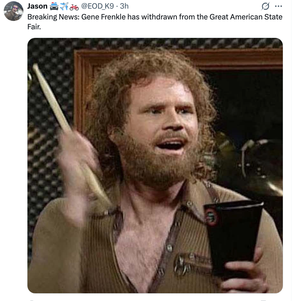 Man enthusiastically plays cowbell successful  beforehand   of a microphone. He's holding a drumstick and wearing a casual shirt. Text mentions Gene Frenkle withdrawing from a fair