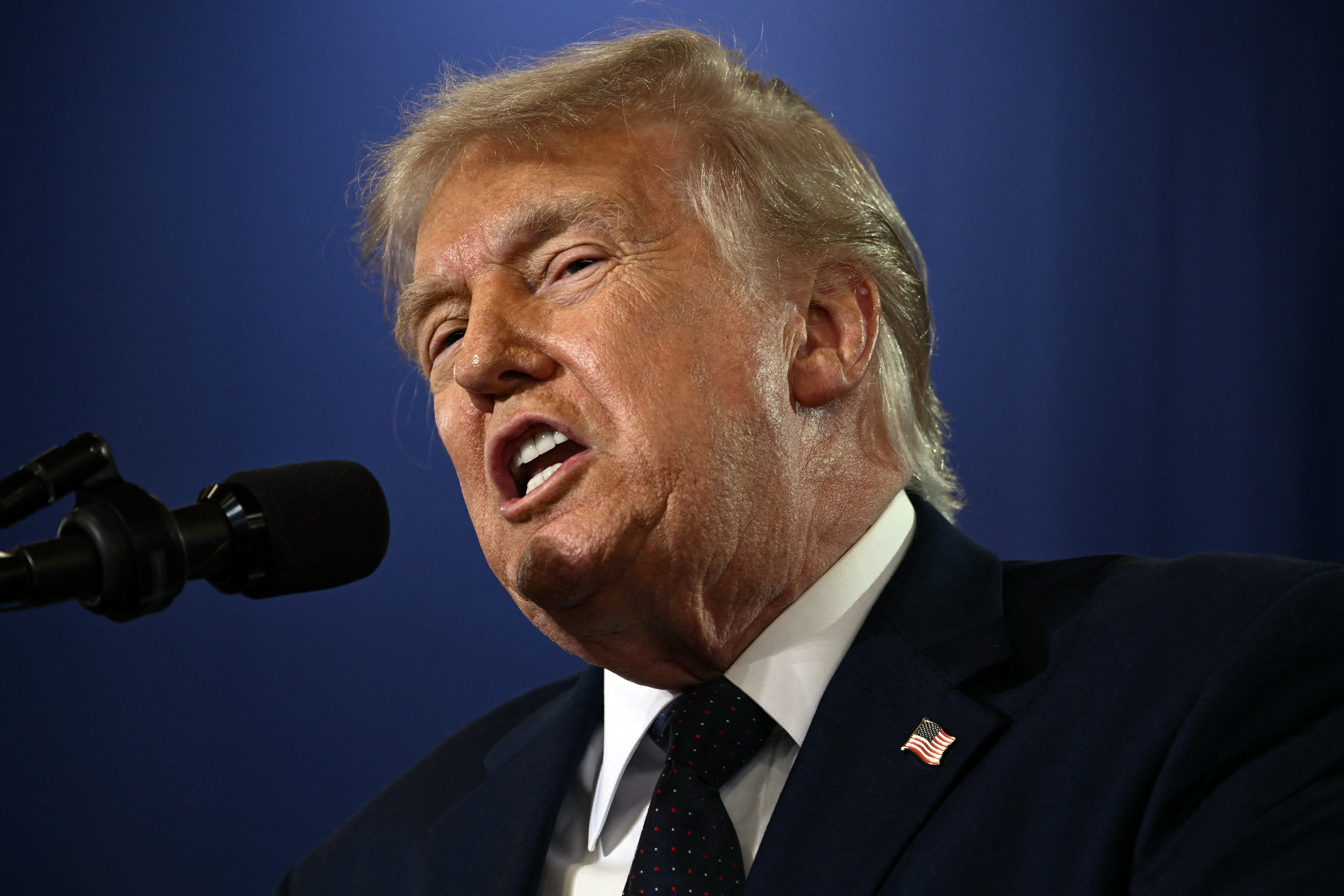 Donald Trump i dress snakker i en mikrofon på et arrangement