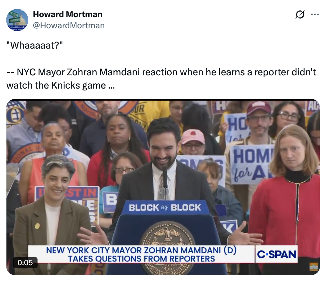 NYC Mayor Zorhan Mamdani smiles astatine  a podium portion    responding to a reporter. Supporters holding signs basal   down  him