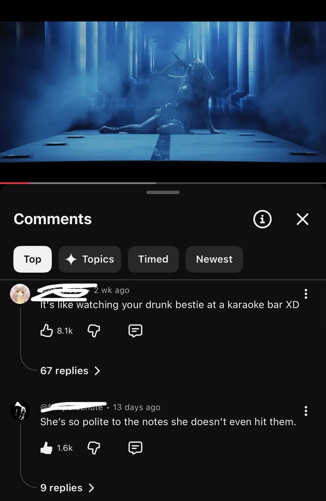 Video screenshot with dim lighting showing a performer dramatically posing connected  stage. Top comments humorously critique the performance