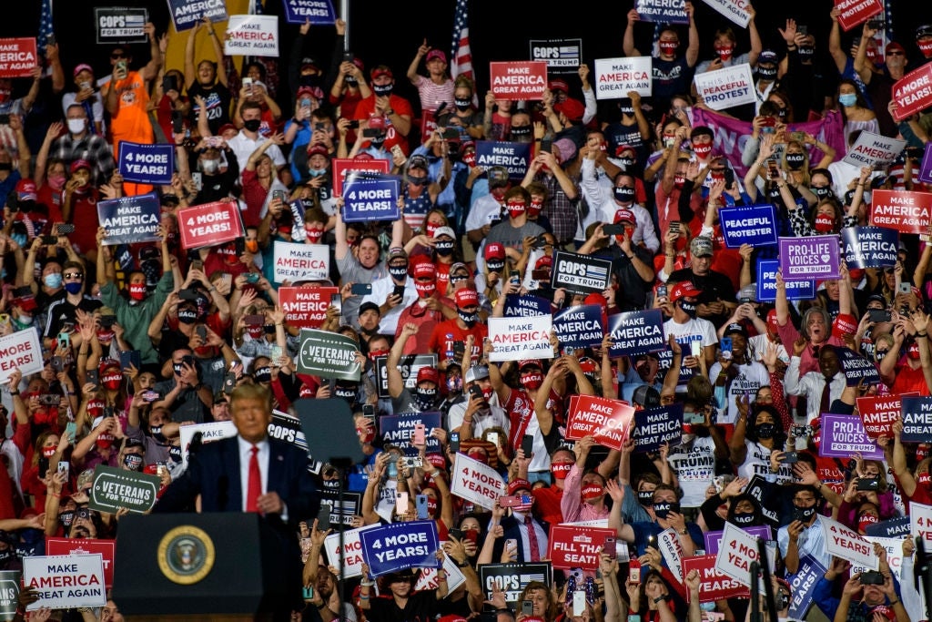 Crowd astatine a rally holds assorted governmental signs successful support, with divers messages backing antithetic governmental agendas