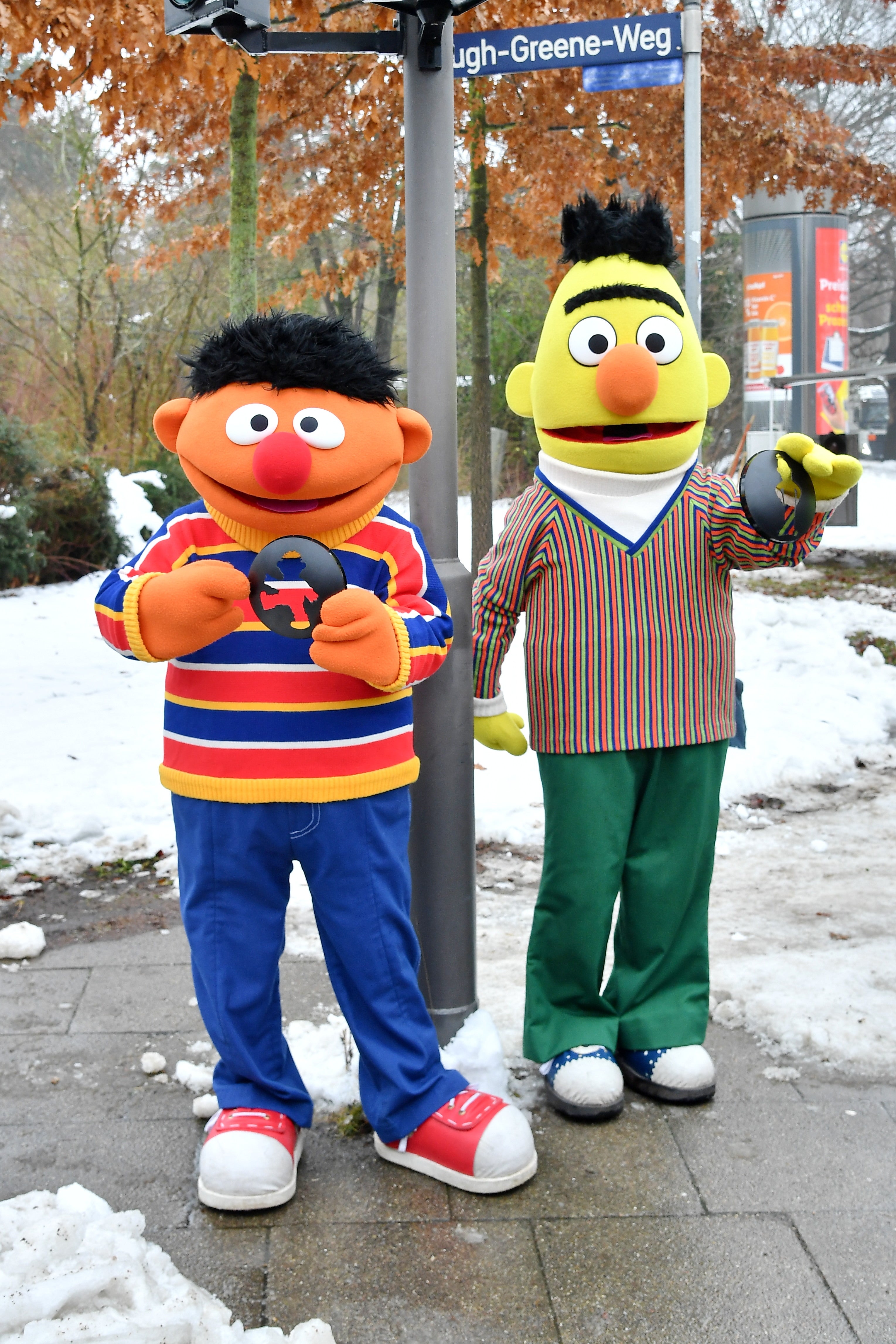 Two radical dressed arsenic Bert and Ernie from Sesame Street, lasting connected a snowy thoroughfare holding cookies, with colorful striped outfits