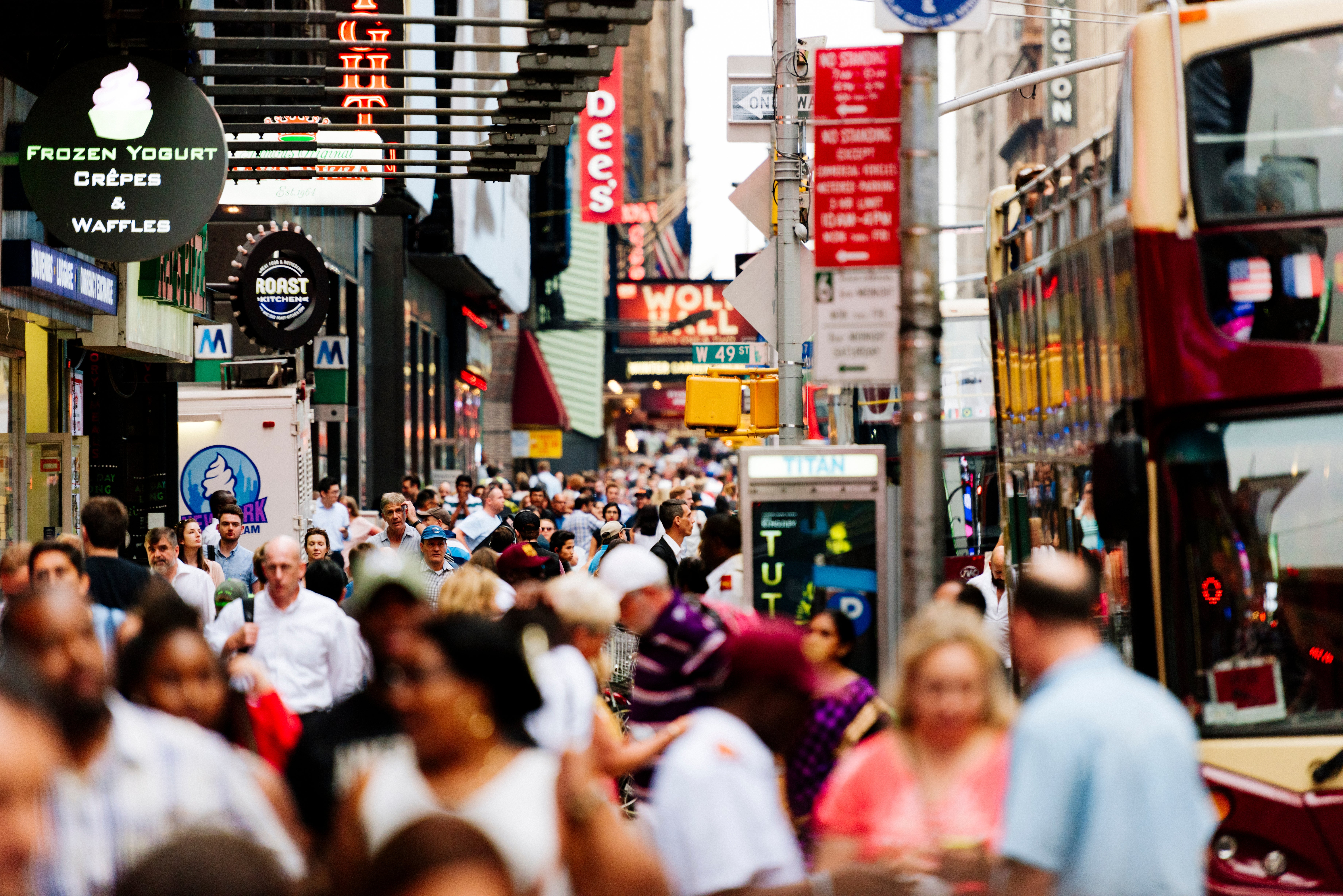 Busy metropolis  thoroughfare  with crowds of radical   walking successful  antithetic  directions, surrounded by storefronts and signs