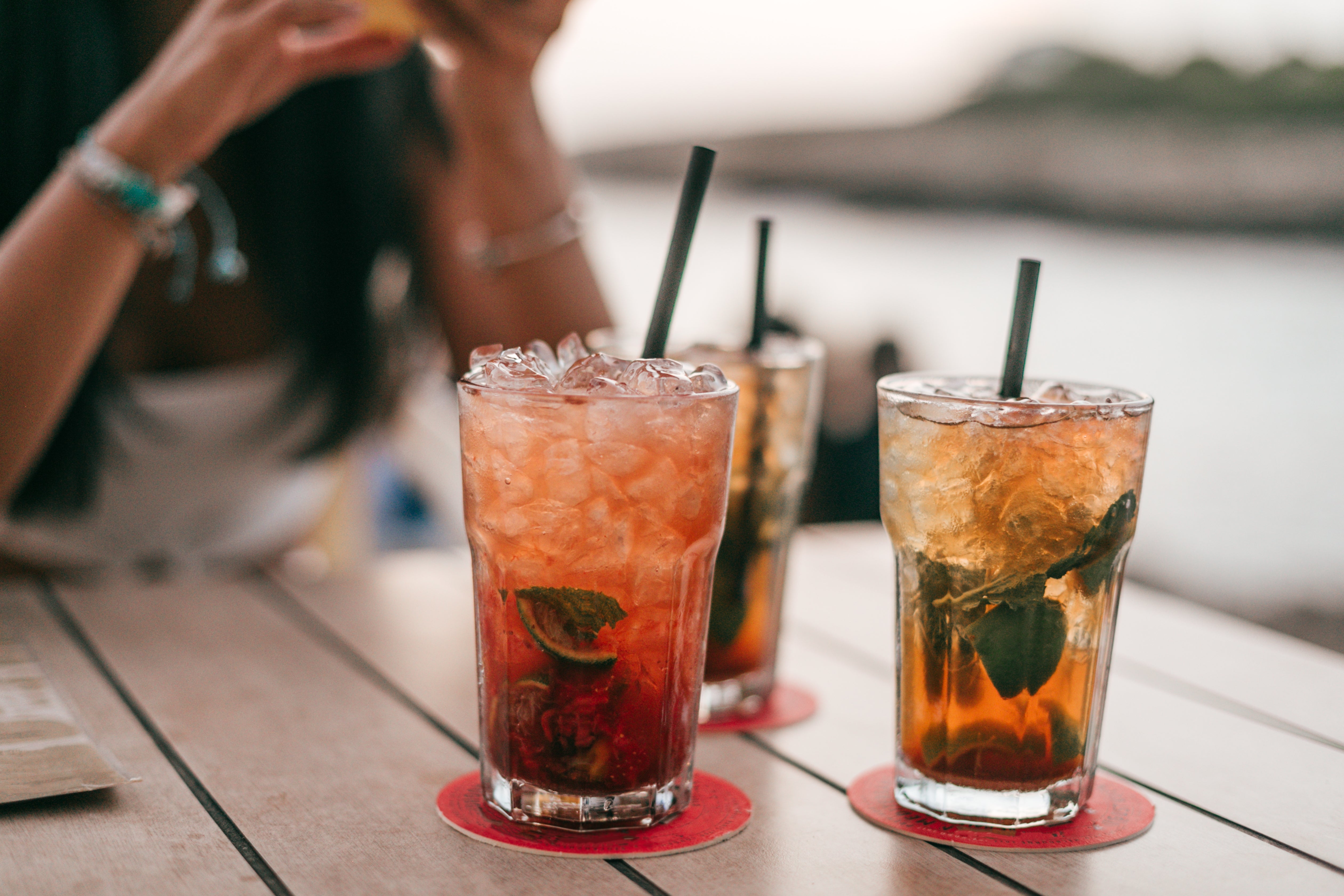 Three iced cocktails with mint leaves connected  a seaside table; a idiosyncratic   is partially disposable   successful  the background
