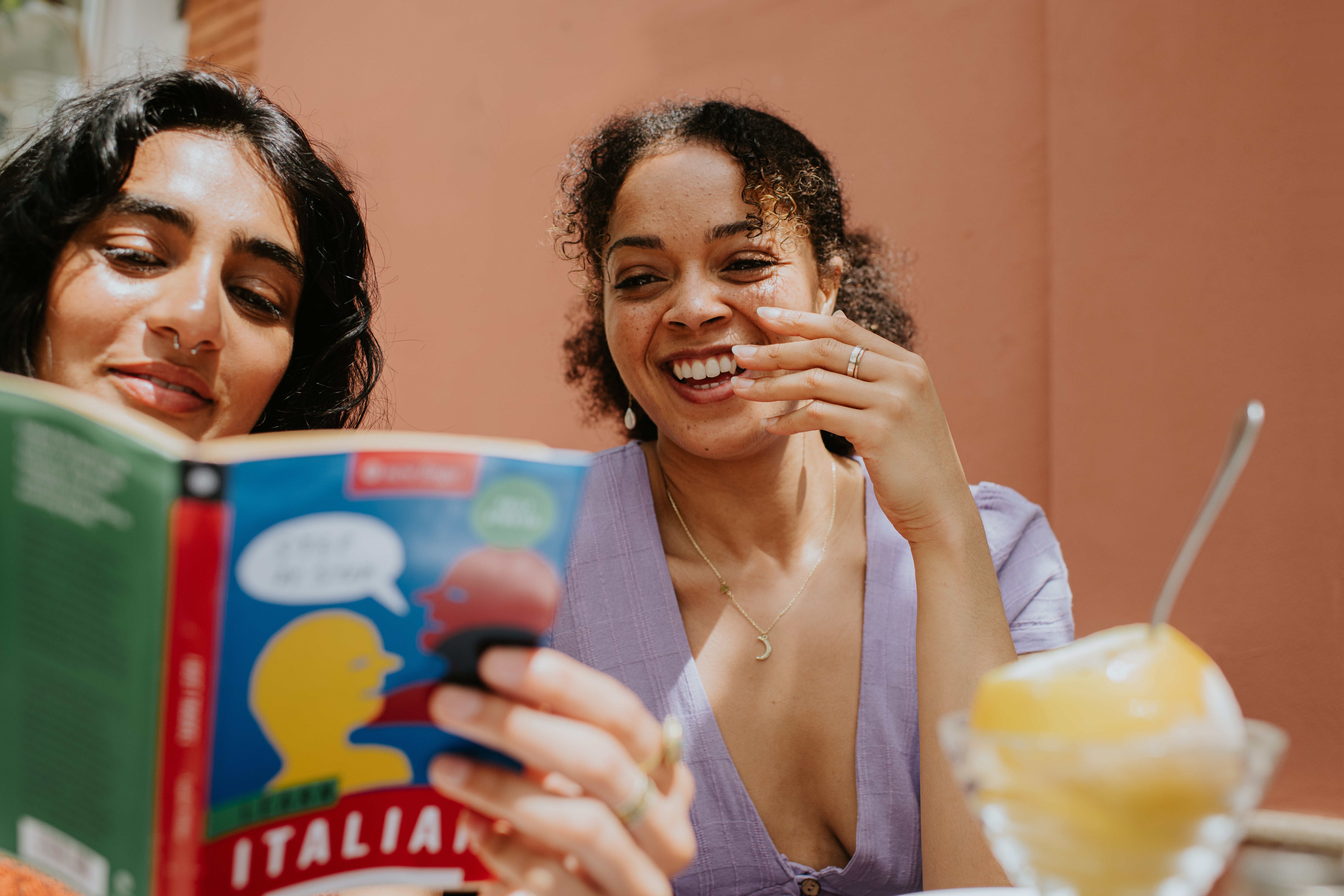 Two radical   are smiling astatine  a publication  titled "Italian." One holds a citrus  dessert successful  beforehand   of them