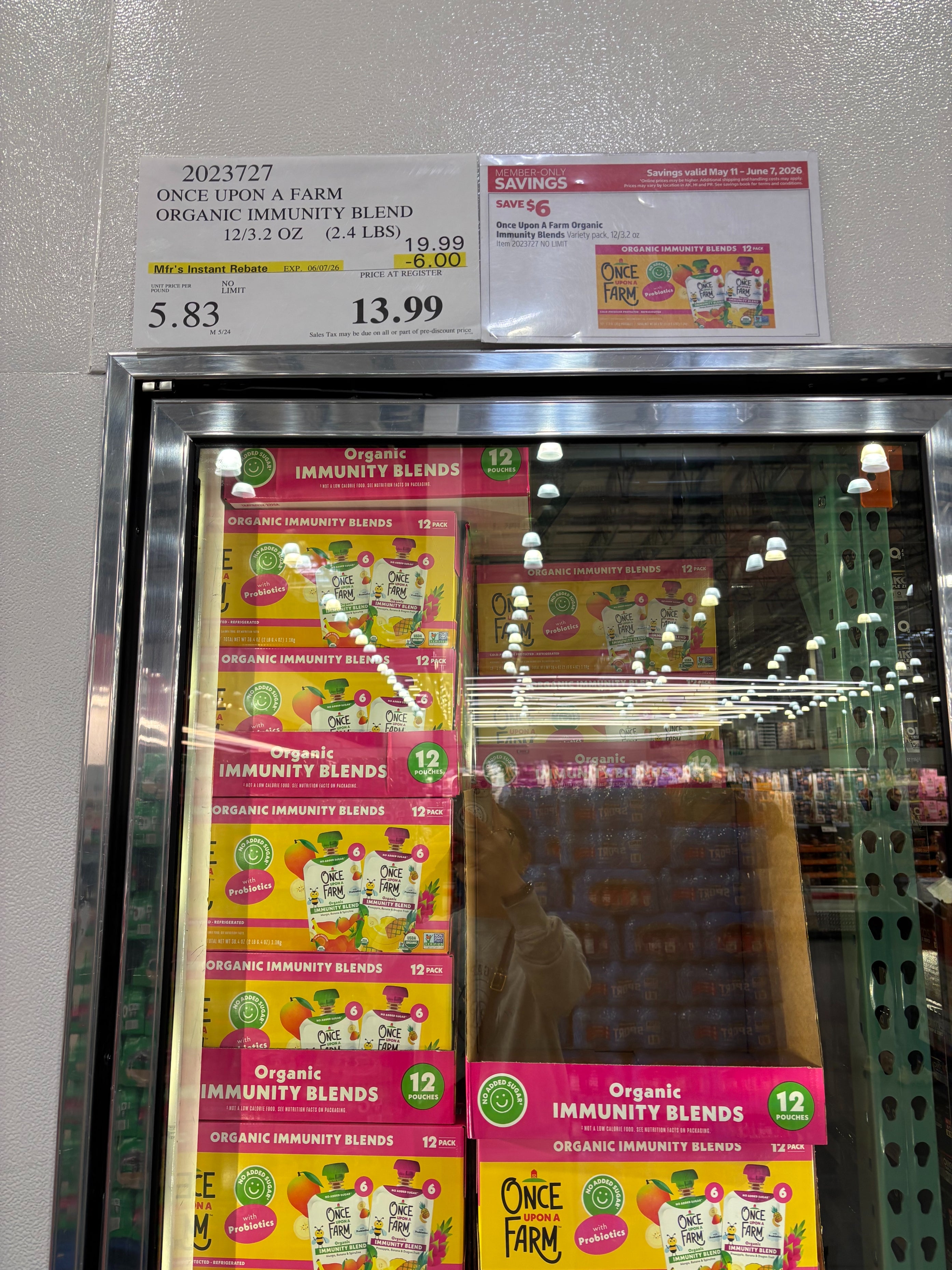 Sale sign for Once Upon a Farm Organic Immunity Blend smoothies at $13.99, reduced from $19.99, showing packaging inside a store cooler