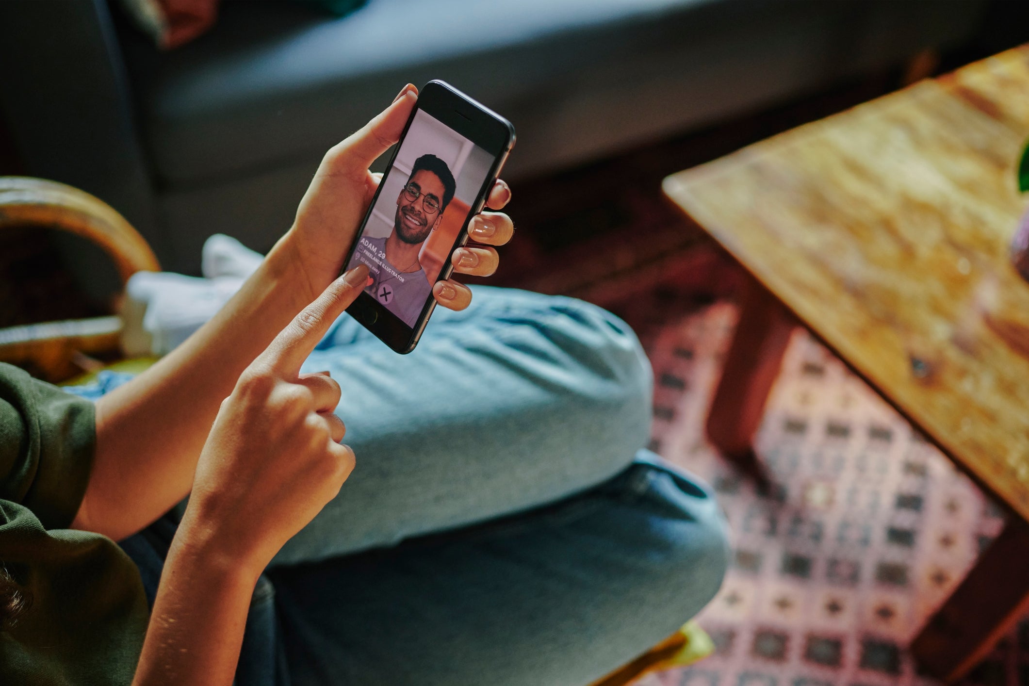 Person som videochatter med en smilende mann på telefonen, sittende uformelt hjemme