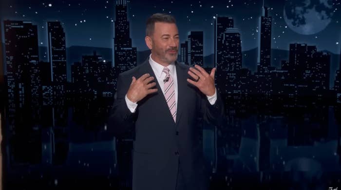 Person successful  a suit   and striped necktie  stands connected  a signifier    with a cityscape backdrop, gesturing with some  hands