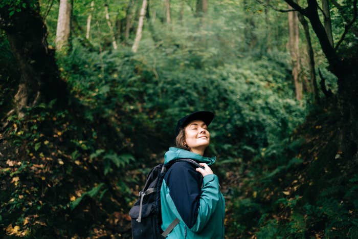 Person successful  outdoor cogwheel  happily hiking done  a lush, greenish  forest
