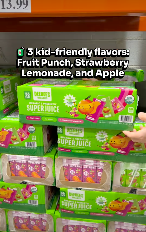 Boxes of Deebee's Super Juice pouches displayed on a store shelf, featuring flavors: Fruit Punch, Strawberry Lemonade, and Apple