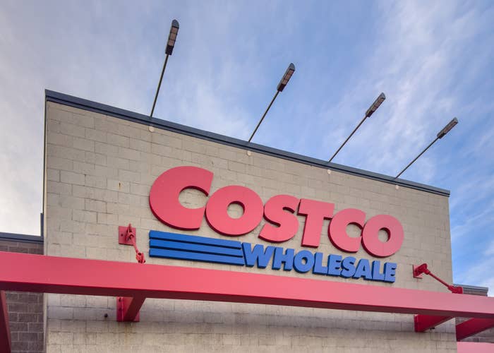 Costco Wholesale storefront with a large logo and clear sky in the background