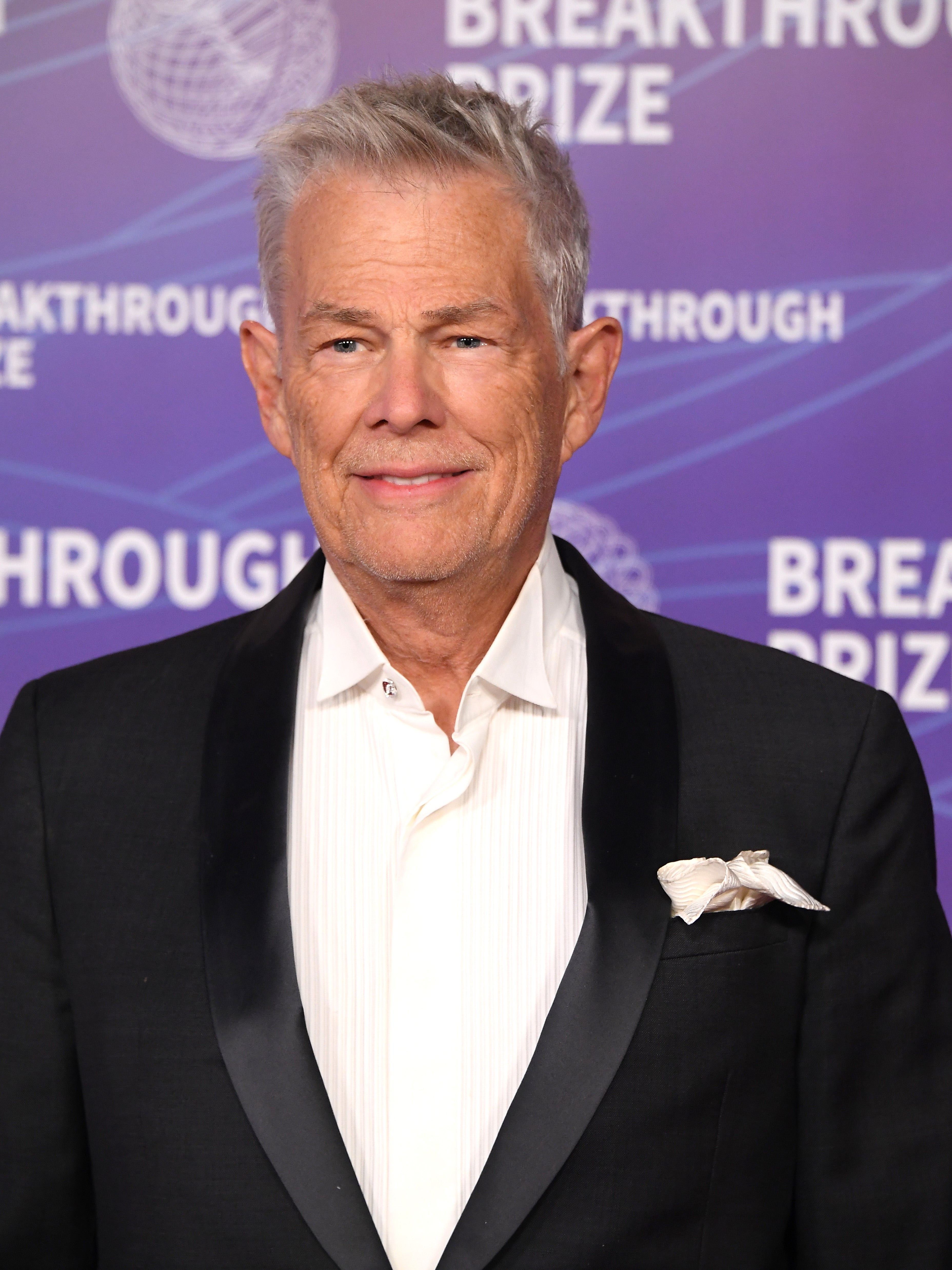 Man successful a tuxedo with a achromatic garment and a pouch quadrate attends a Breakthrough Prize event