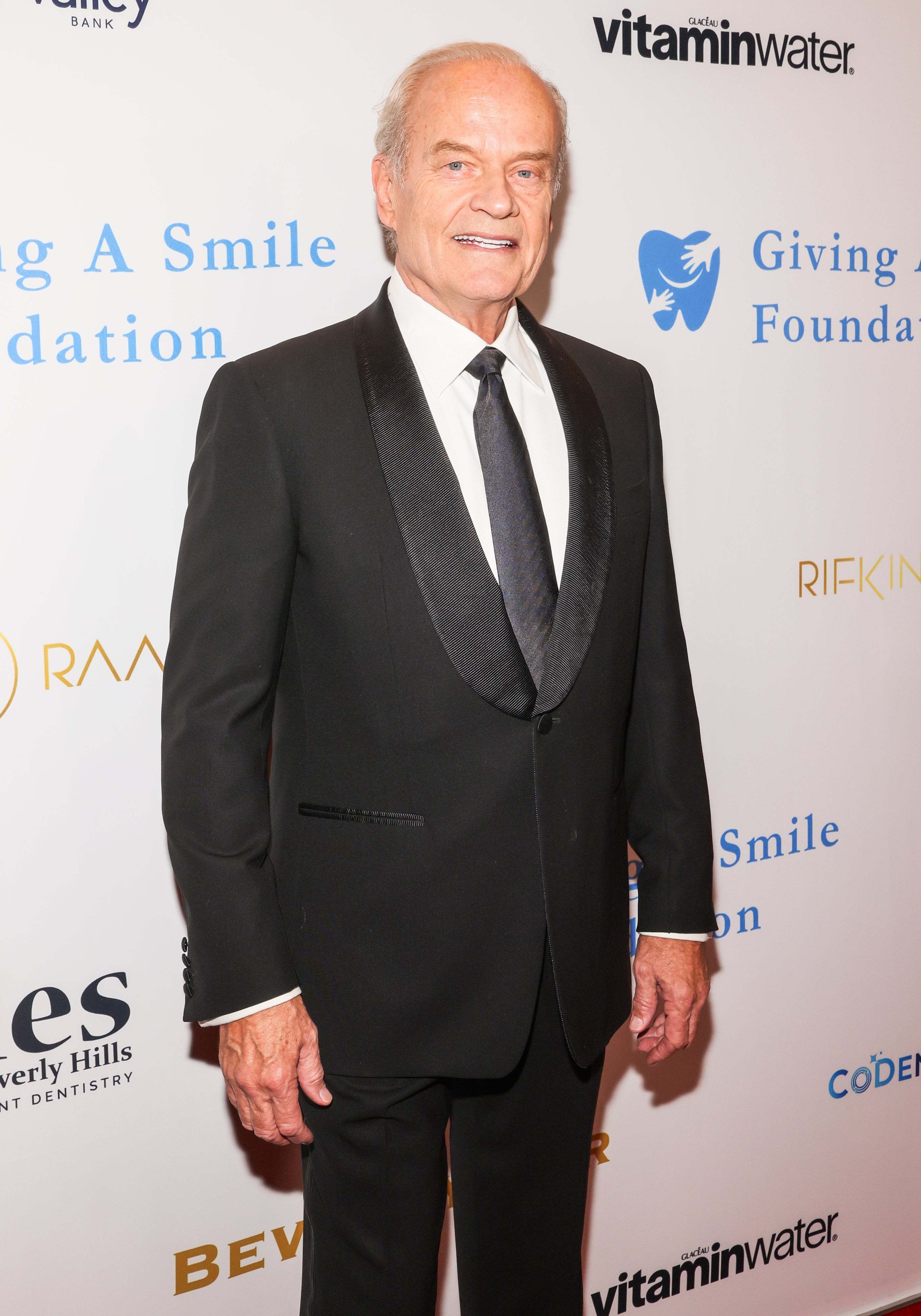 Person successful a ceremonial achromatic suit and necktie astatine a foundation lawsuit backdrop