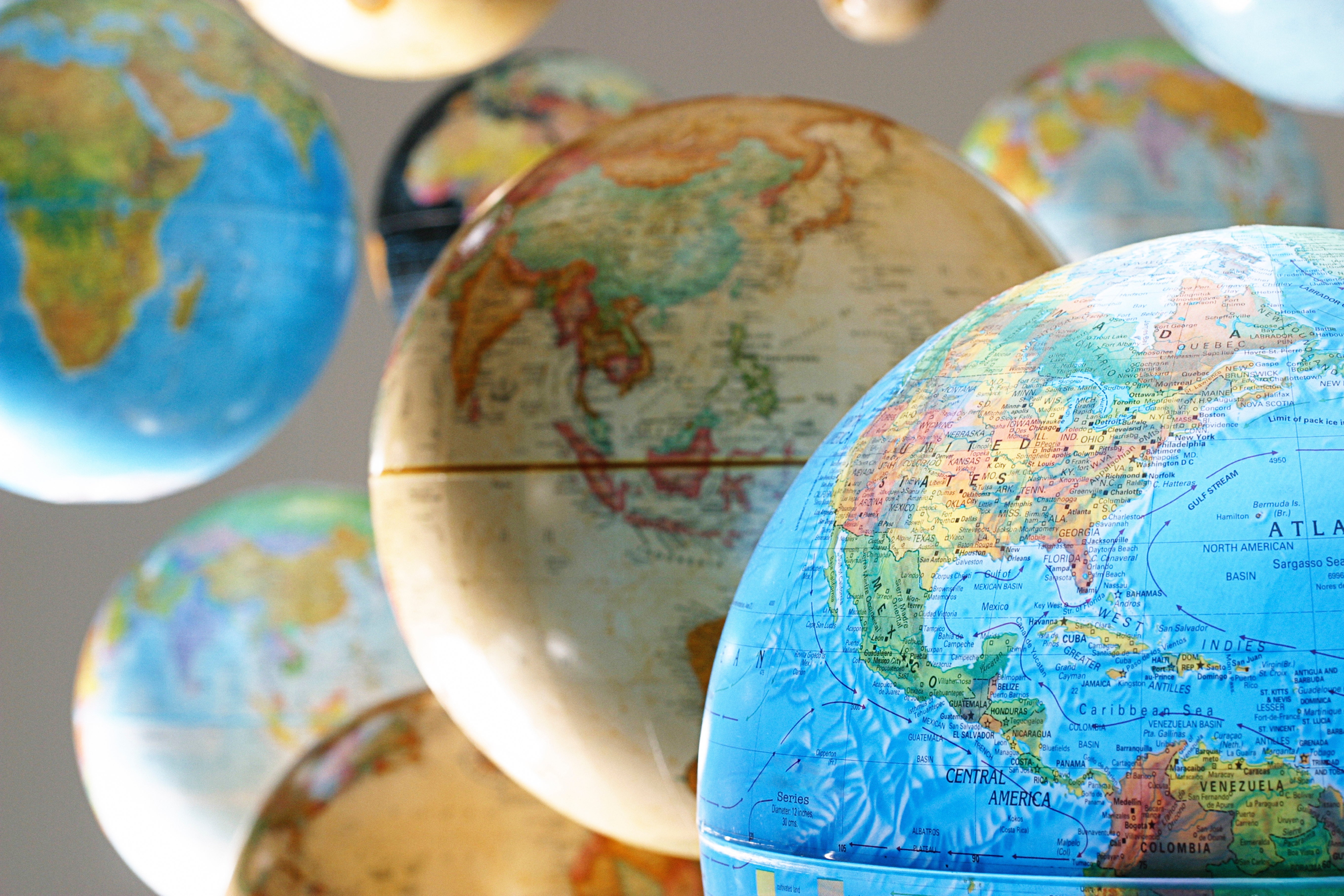 Globes floating in mid-air, displaying various parts of the world map