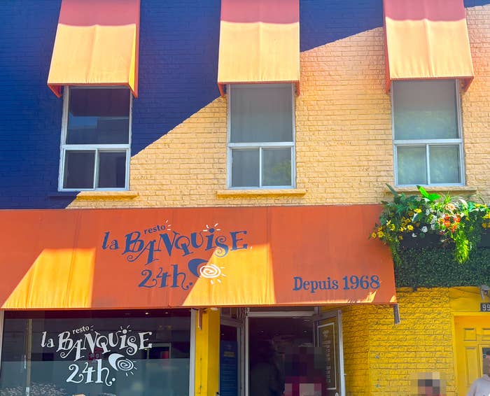 Exterior of La Banquise edifice  with striped awnings and floral decor, specializing successful  poutine since 1968