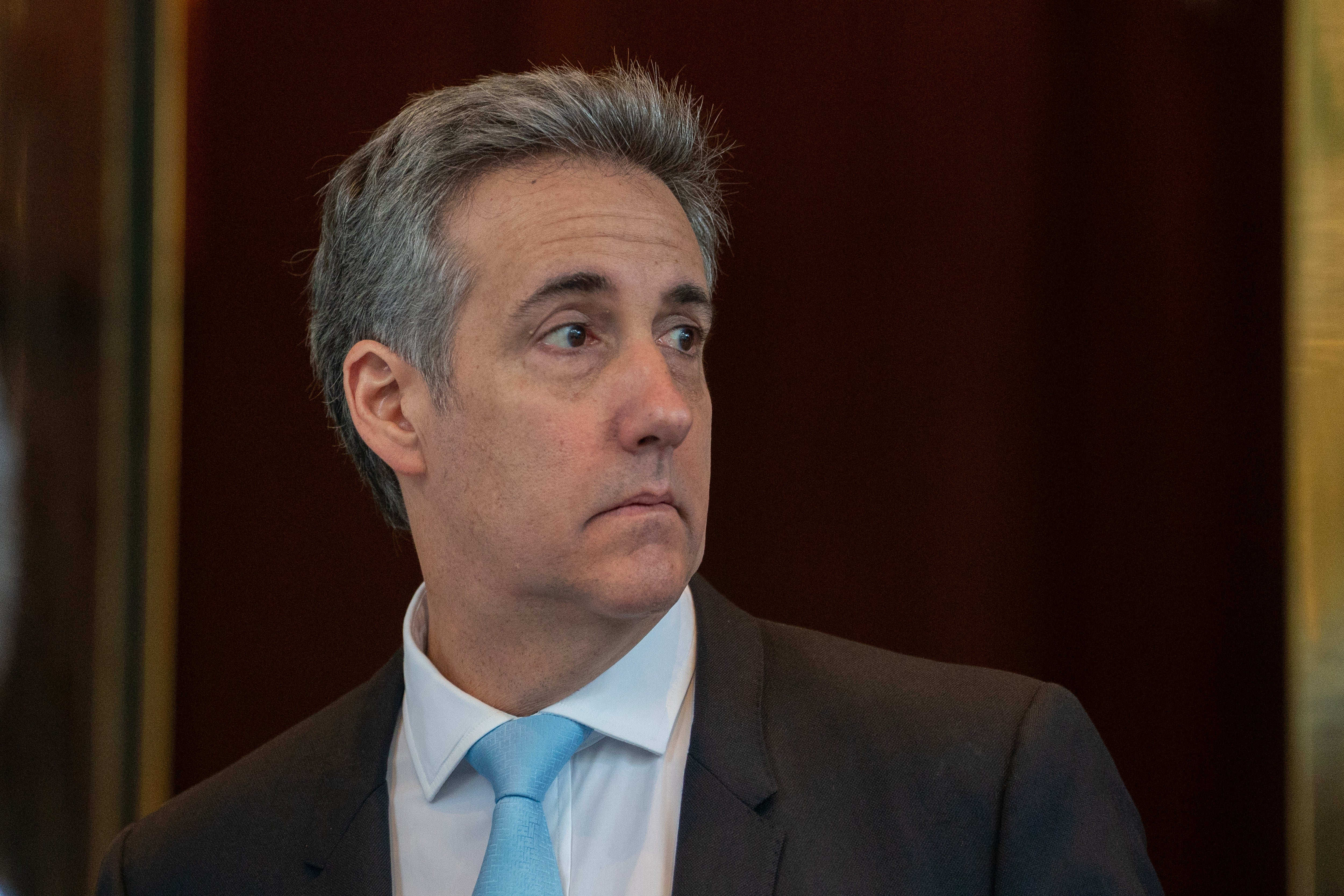 A idiosyncratic   successful  a suit   and necktie  looks disconnected  to the broadside  astatine  an event
