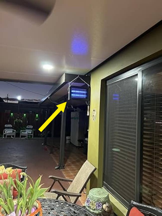 Covered patio with outdoor seating, a decorative hanging light, and plants. Ideal for relaxed gatherings
