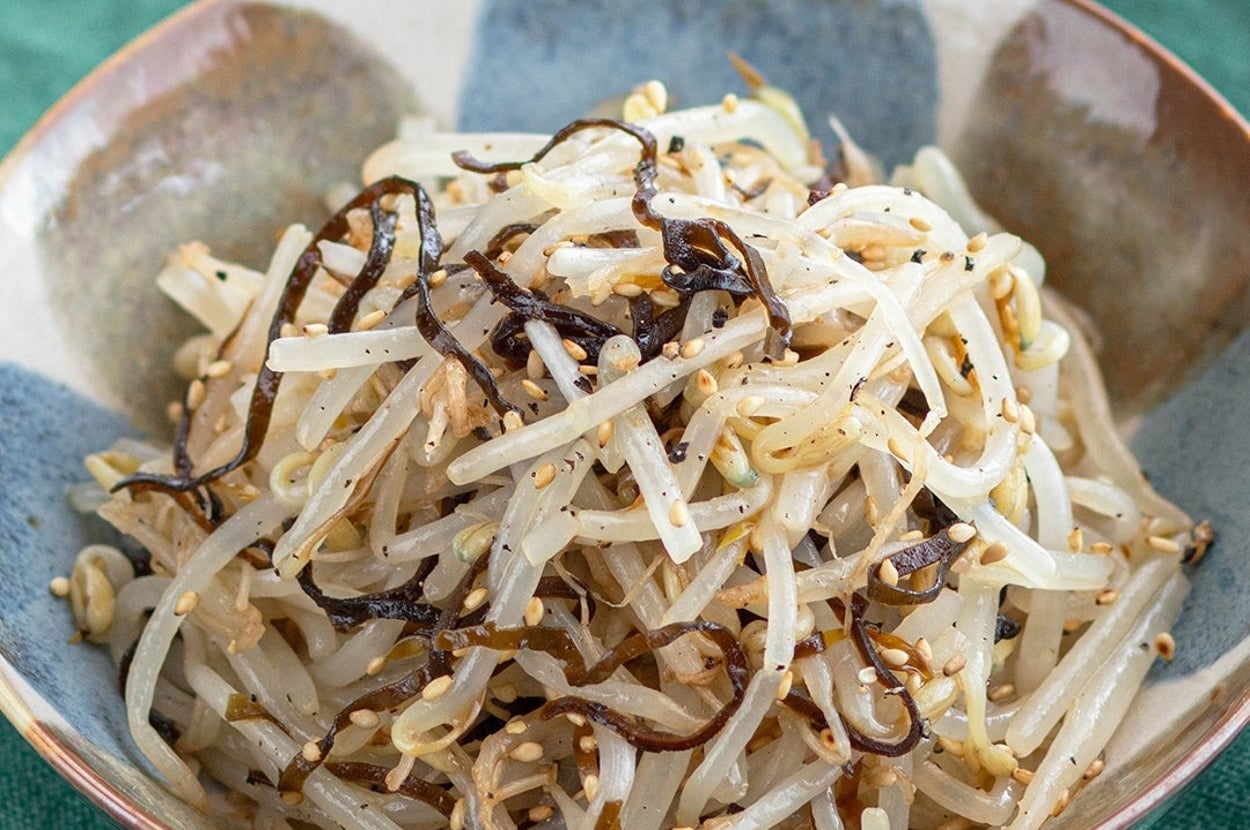 もやしと昆布の和え物が器に盛られている。ゴマがトッピングされており、シンプルでヘルシーな料理。
