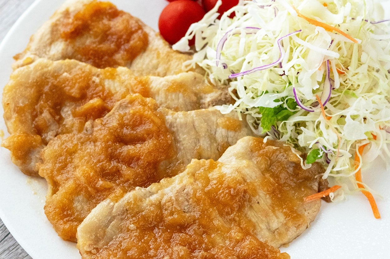 豚肉の生姜焼きとキャベツサラダ、トマトが皿に盛られている。