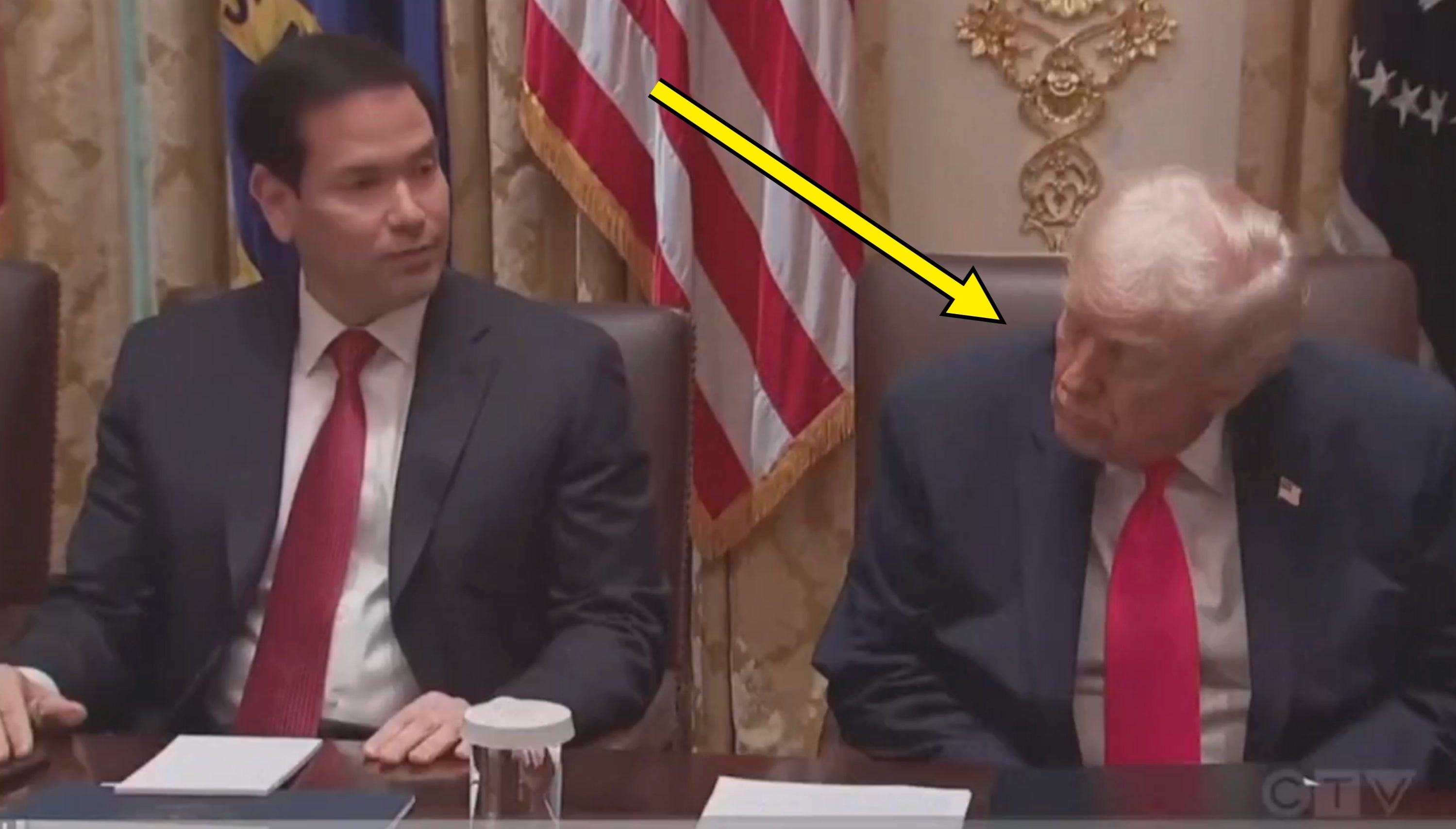 Two men successful  suits beryllium   astatine  a array  with an American emblem  successful  the background, engaged successful  discussion