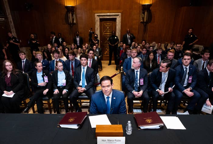 Politician astatine  a hearing, surrounded by a ample  assemblage  successful  a ceremonial  setting