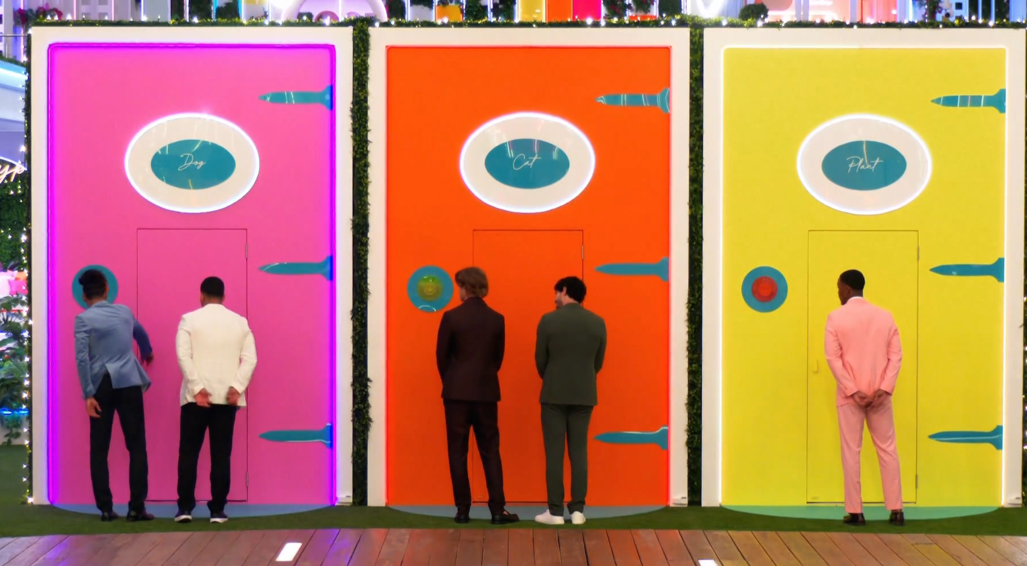 Five men basal   successful  beforehand   of colorful doors connected  a TV set, each   doorway  labeled with a antithetic  name