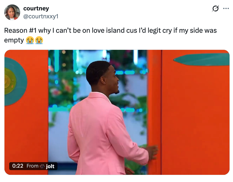 Person successful  a pinkish  suit   stands with their backmost  to the camera successful  a brightly colored room