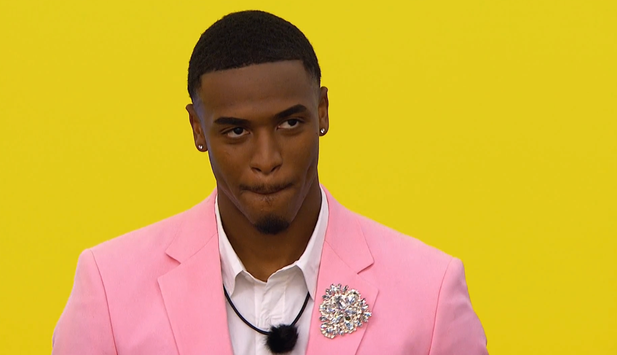 Person successful  a tailored suit   with a floral brooch, lasting  against a plain background