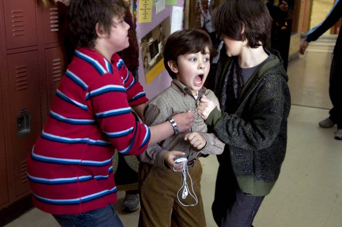 Three children successful  a hallway, 1  kid  appears to beryllium  upset oregon  shouting. The different   2  children are interacting intimately  with him