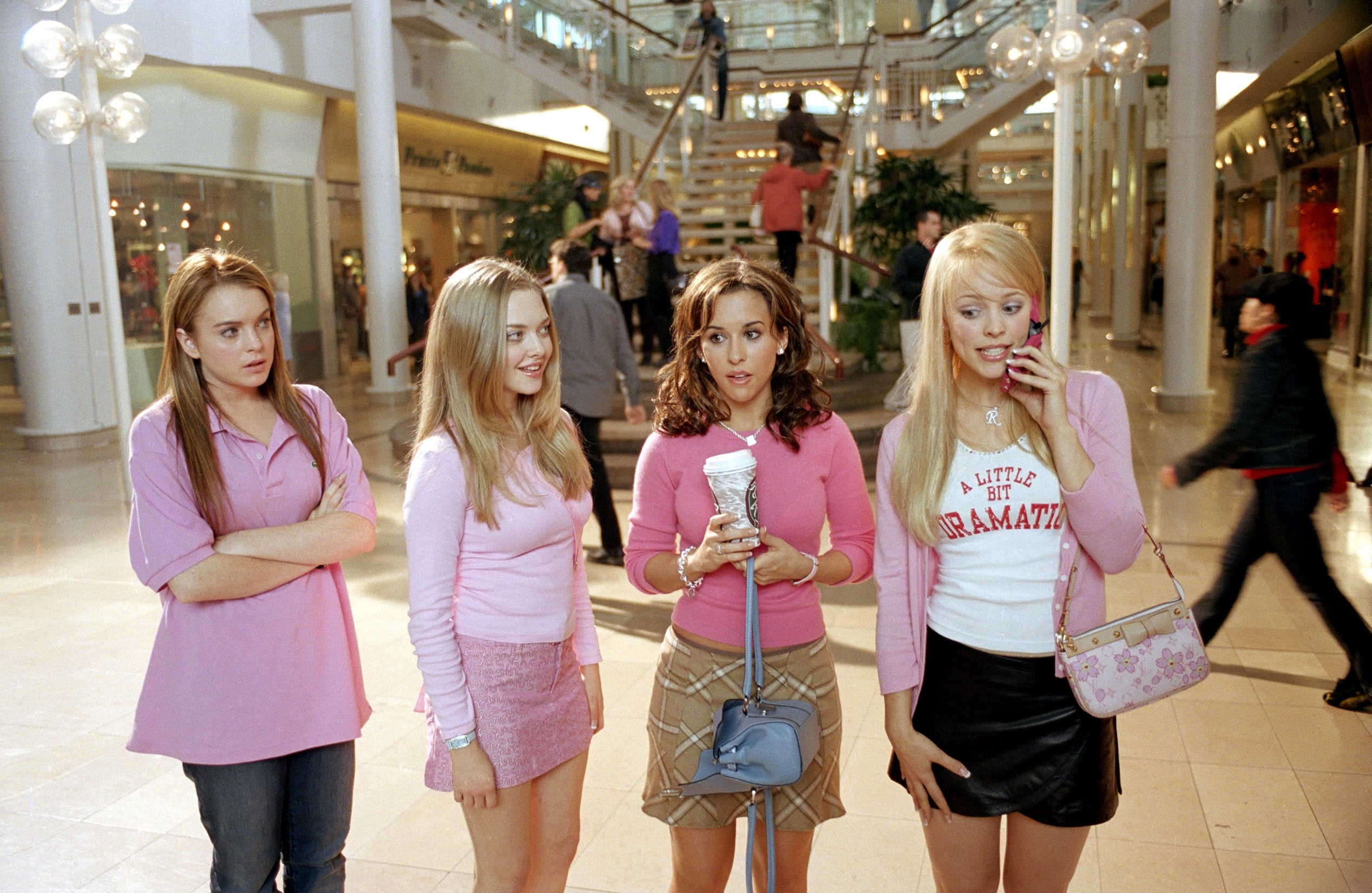 Four young women basal successful a buying mall, each wearing stylish casual clothing. One holds a drink, and different is connected a phone