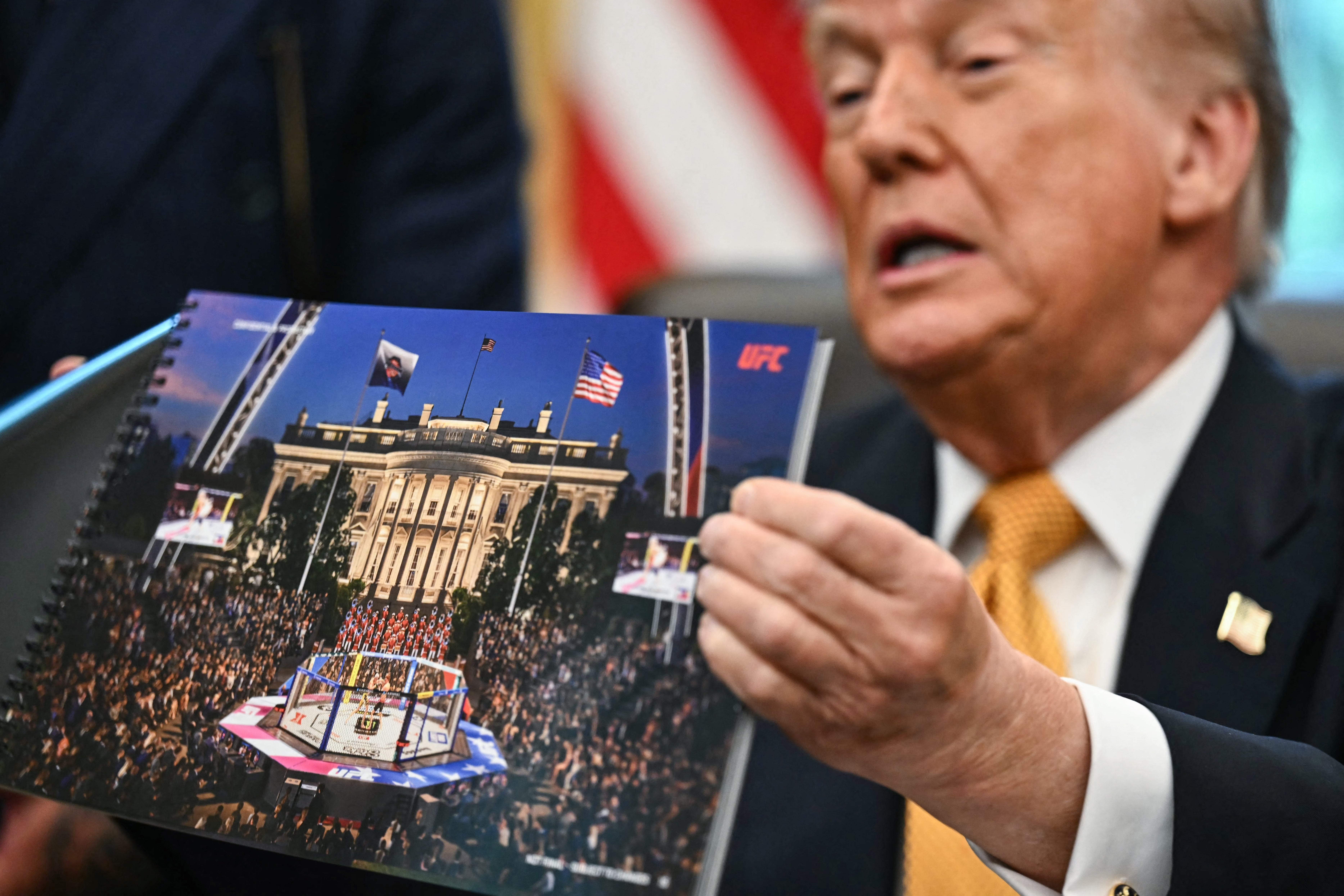 En person holder et redigert bilde som viser en UFC-ring foran Det hvite hus, med flagg synlige i bakgrunnen
