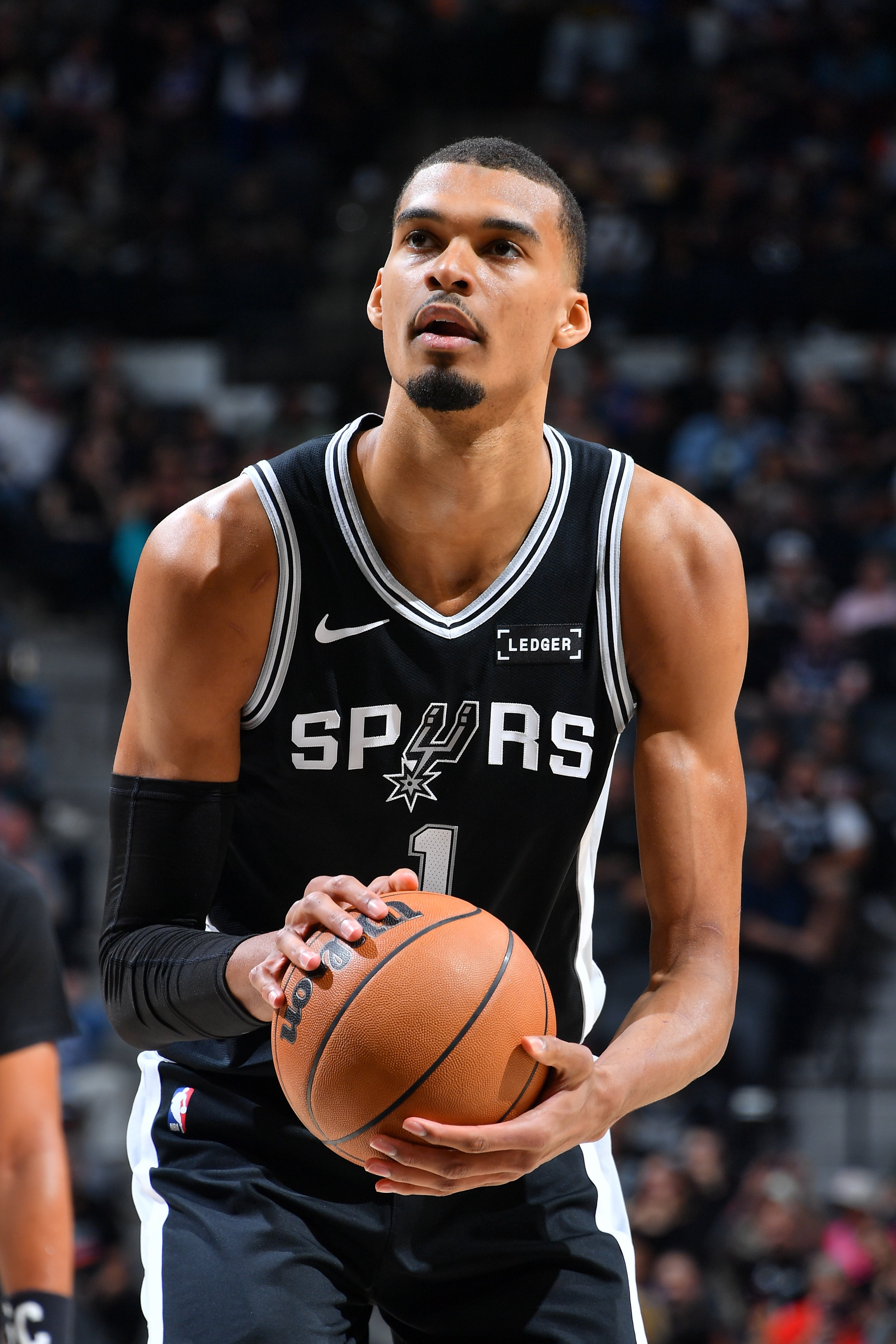 Basketball player in Spurs uniform prepares to shoot a free throw during a game