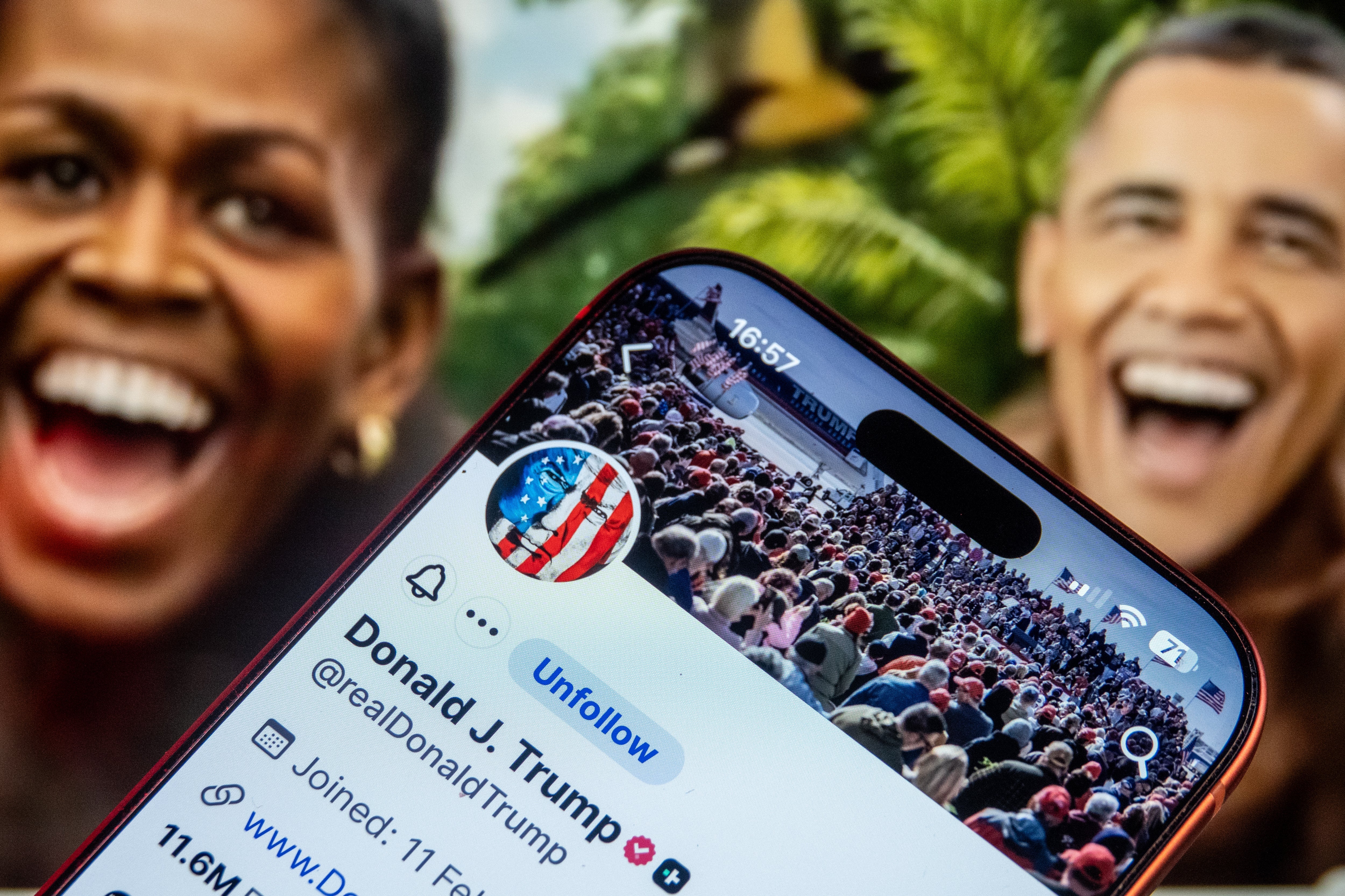 Nærbilde av en telefon som viser en sosial medieprofil med Michelle og Barack Obama smilende i bakgrunnen