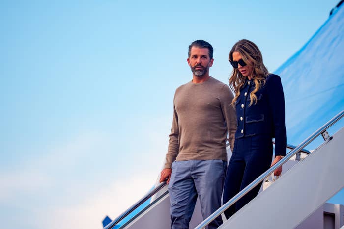 Man successful  a sweater and pistillate   successful  a tailored overgarment   with sunglasses walking down   airplane stairs