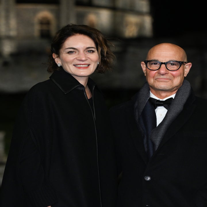 Two individuals in formal attire pose for a photograph at an elegant outdoor event, standing together and smiling