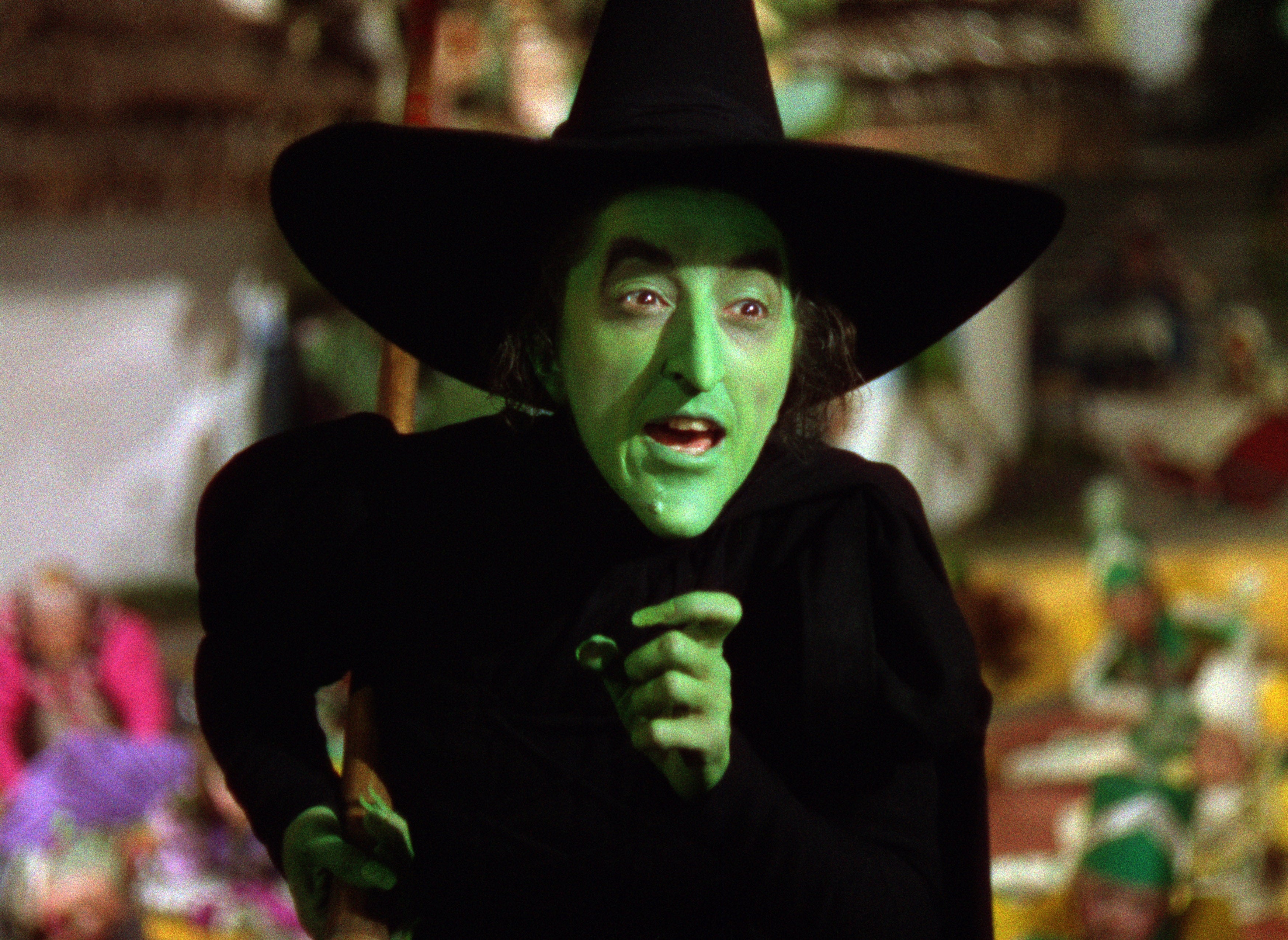 Character dressed arsenic a witch with a pointed chapeau and a greenish face, performing successful a classical movie scene