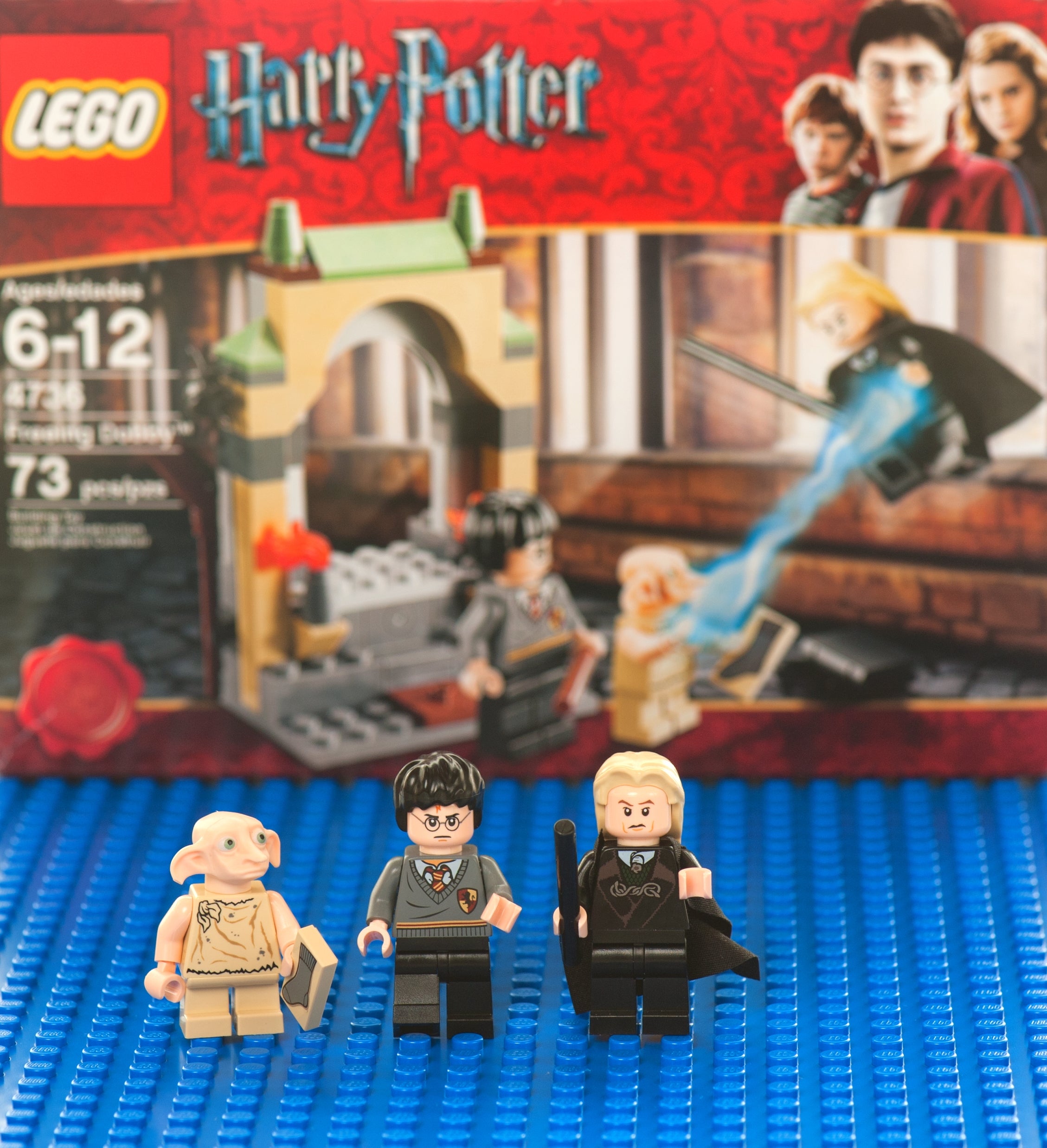 LEGO Harry Potter acceptable with minifigures of Dobby, Harry Potter, and different character. Box shows a magic duel country backdrop