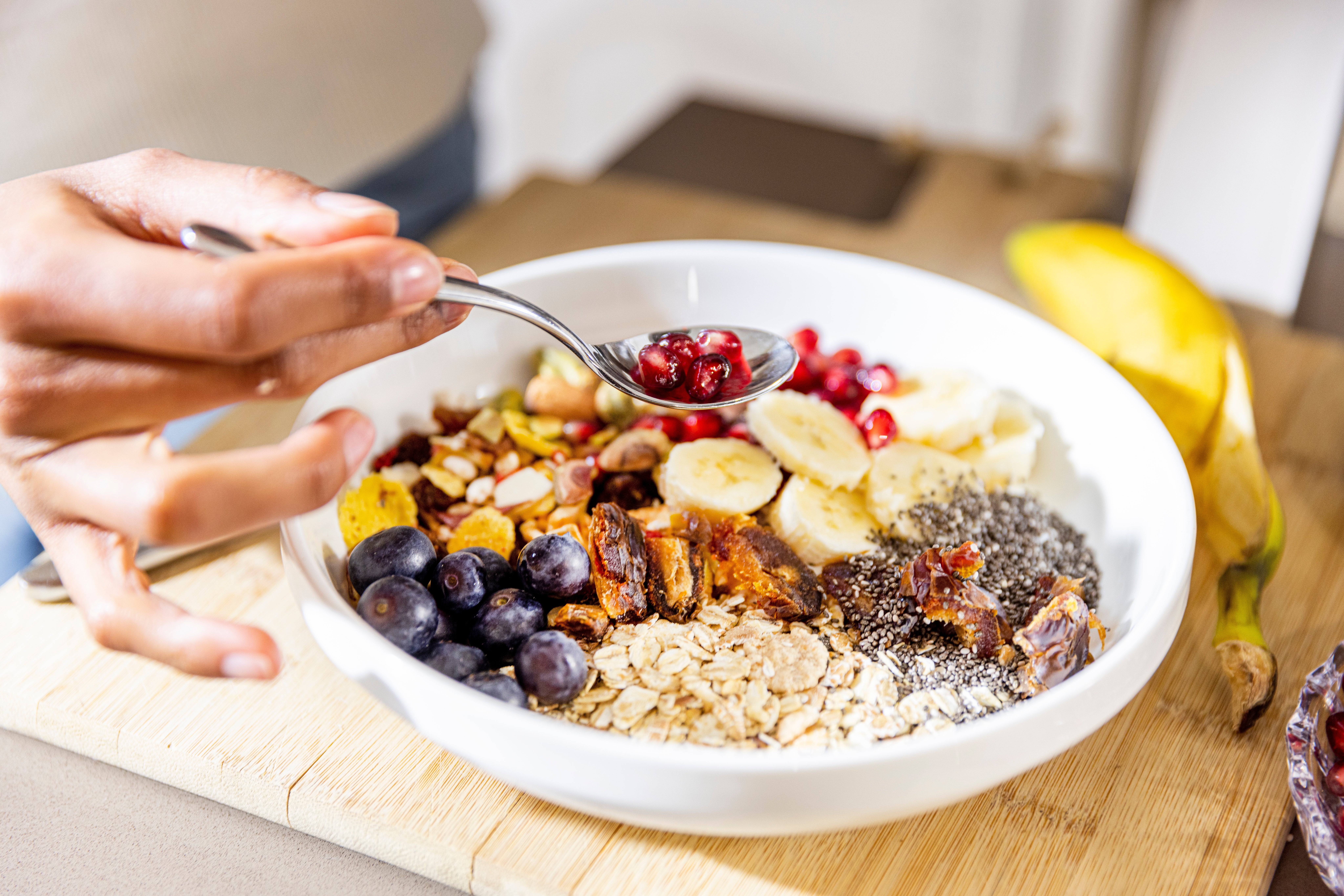 A vessel  of fruit, chia seeds, granola, and yogurt