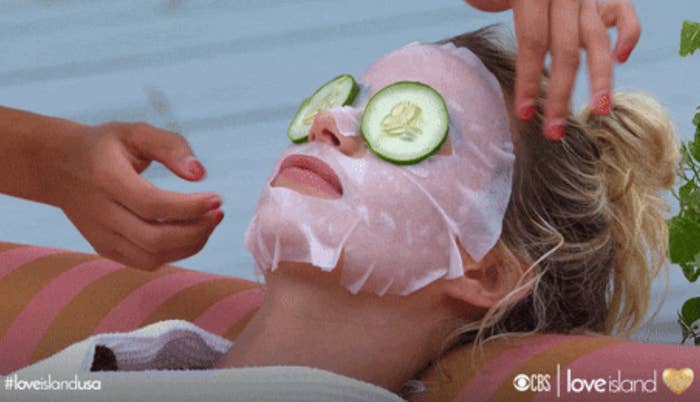 Person relaxing with a expanse  disguise  and cucumber slices connected  their eyes, during a self-care session. Hands are mildly  adjusting the mask
