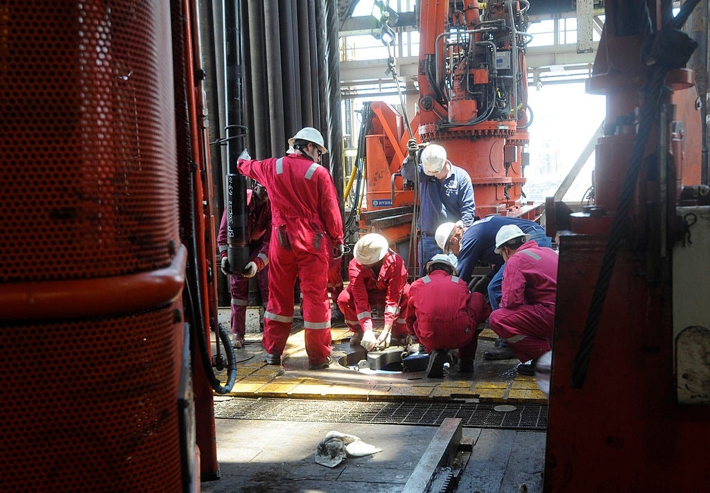 Workers successful protective cogwheel and helmets collaborate connected a task astatine an concern tract with dense machinery successful the background