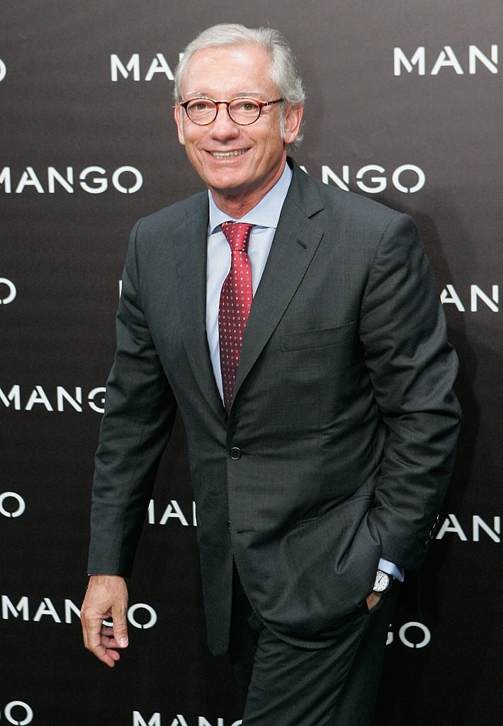 Man successful a suit and polka dot necktie poses successful beforehand of a "MANGO" branded backdrop astatine an event
