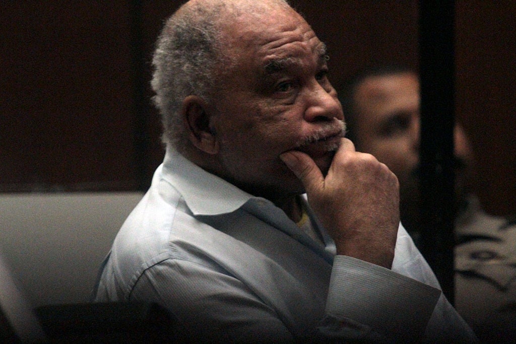 Man sitting thoughtfully successful a courtroom setting, wearing a light-colored shirt