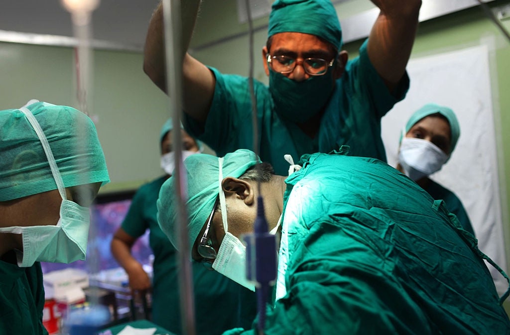 Surgeons successful masks and scrubs execute country nether agleam lights successful an operating room