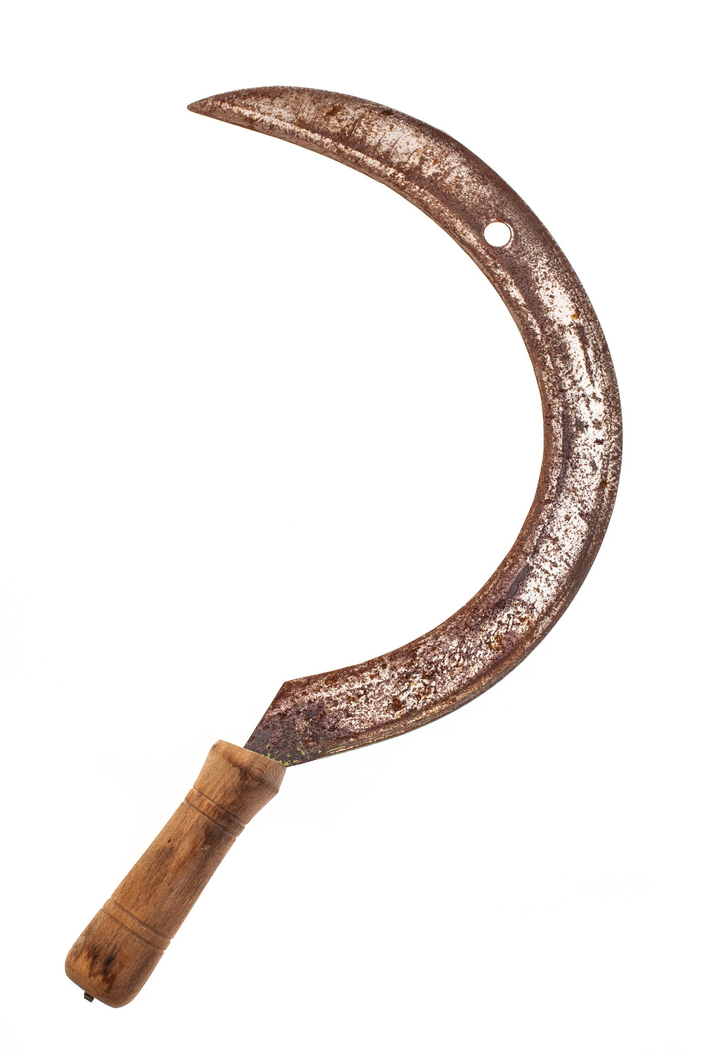 A rusty sickle with a woody handle, showing signs of property and wear, isolated connected a plain background