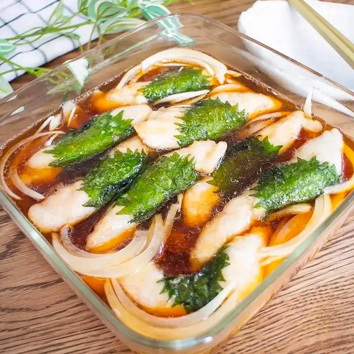 ガラス容器に盛られたささみと玉ねぎが入った料理。上に緑の葉がのせられている。