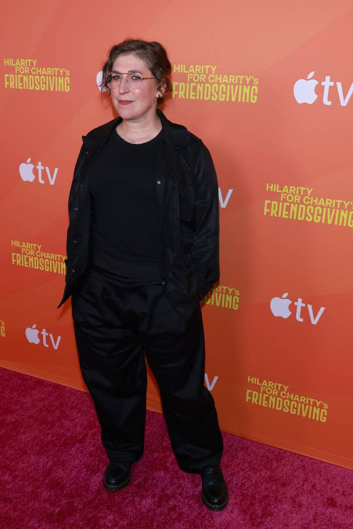 Mayim Bialik successful  casual attire astatine  an lawsuit   titled "Hilarity for Charity's Friendsgiving" with an Apple TV+ backdrop